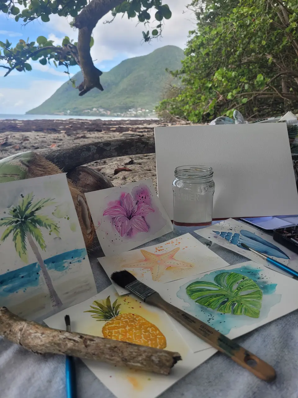 Cartes postales tropicales en cours, posées sur une serviette face au rocher du Diamant